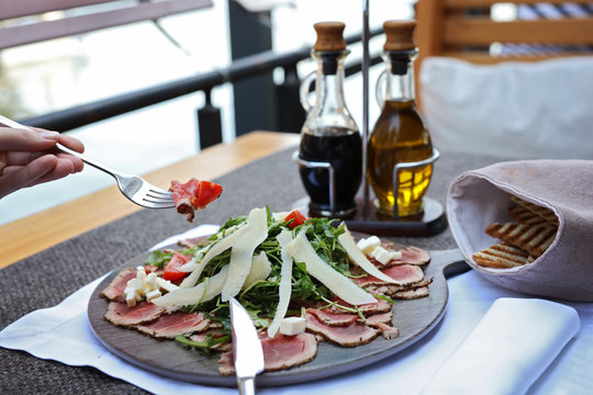 Woman enjoying her launch beef steak salad close up. Healthy eating concept