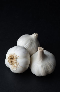 Group of Three Whole Garlic Bulbs on Black