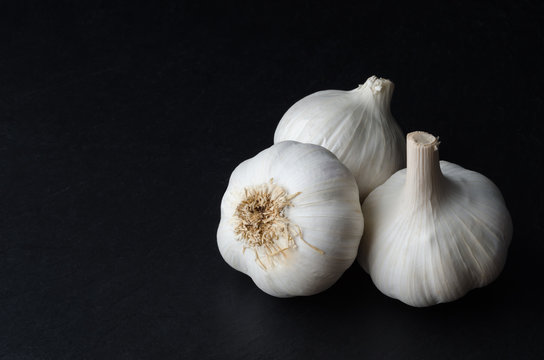 Three Whole Garlic Bulbs on Black