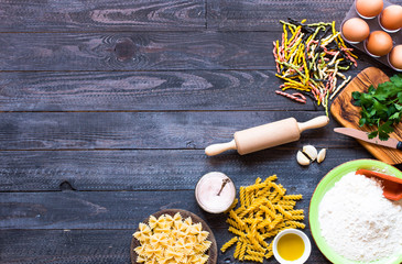 Fototapeta na wymiar Pasta background. Several types of pasta with vegetables, Free space for text. Top view
