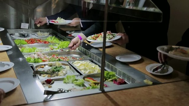 People impose food. Catering. Impose Salad. Food Distribution Table.