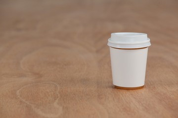 Disposable coffee cup on wooden background