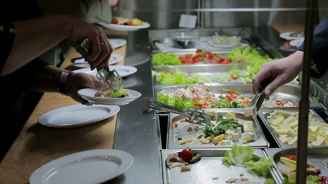 People impose food. Catering. Impose Salad. Food Distribution Table.