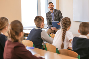 Pupils listening teacher in classroom