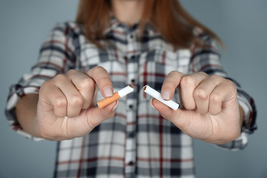 Closeup view of woman breaking cigarette in hands