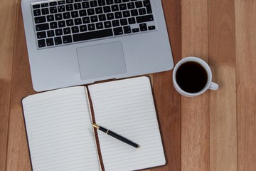 Cup of coffee with laptop, organizer and pen