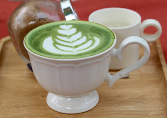 A cup of hot green tea  on table.