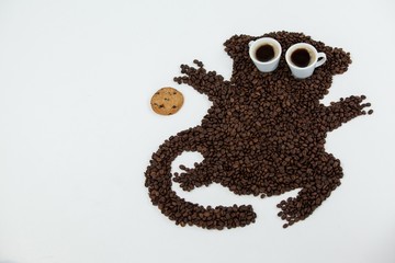 Coffee beans and cups forming monkey with cookie