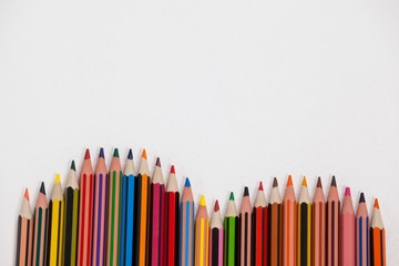 Close-up of colored pencils arranged in a wave pattern