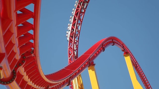 People ride a rollercoaster at an amusement park.