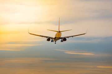Fototapeta na wymiar Descending airplane in sunset with cloud