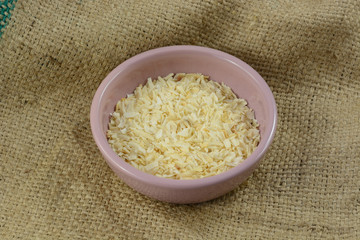 Dried onion flakes seasoning in small condiment bowl on burlap