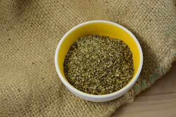 Marjoram leaves herb is small spice dish on burlap