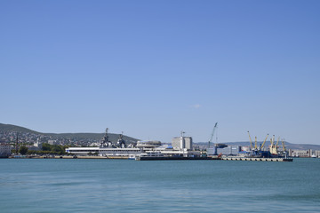 Fototapeta na wymiar Cargo port with port cranes. Sea bay and mountainous coast.