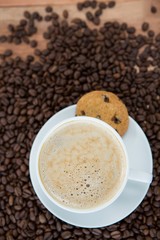 Coffee cup with cookie and coffee beans