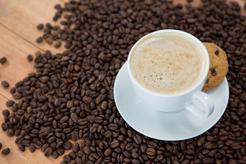 Coffee cup with cookie and coffee beans