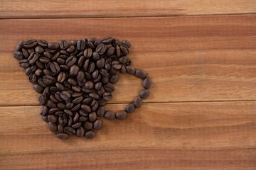 Coffee beans forming shape of cup 