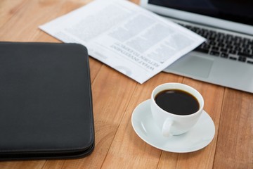 Coffee cup with file folder and laptop