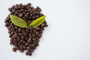 Roasted coffee beans arranged with leafs