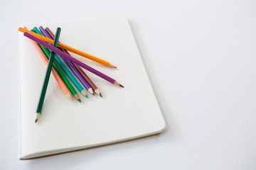 Colored pencils kept on the book