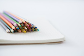 Colored pencils kept on the book