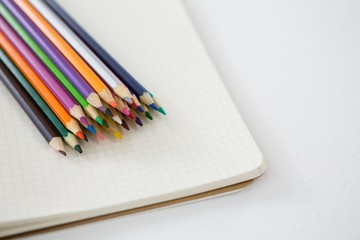 Colored pencils kept on the book
