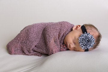 Beautiful newborn baby girl swaddled and sleeping