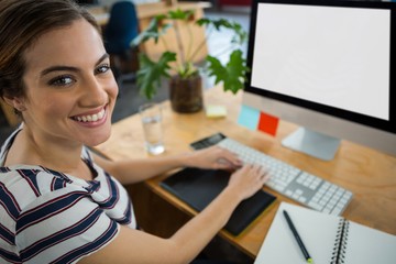 Smiling female graphic designer working on computer