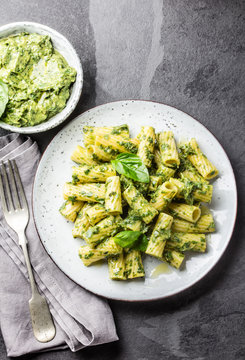 Vegetarian pasta with green avocado and herbs sauce pesto. Top view