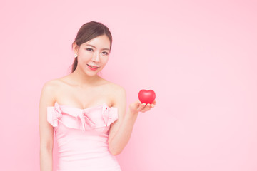 Obraz na płótnie Canvas Beautiful asian woman holding with little heart, isolated with pink background.