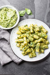 Vegetarian pasta with green avocado and herbs sauce pesto. Top view