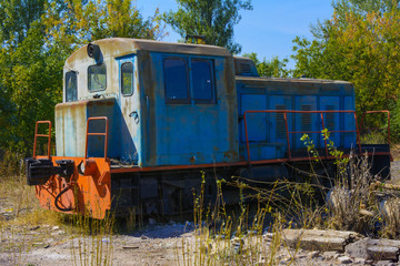 Old rusty locomotive in an abandoned factory in the industrial zone