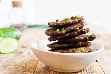 Fritters of liver.  Pancakes from the liver.  Food photo. Wooden background.