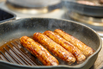 Sausage of beef fried in a skillet-grill.