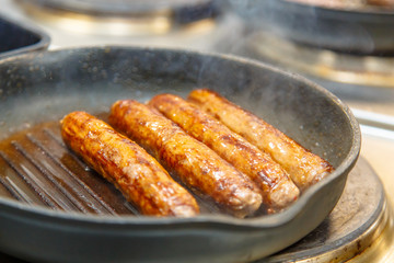 Sausage of beef fried in a skillet-grill.