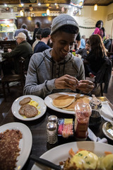 A young, hip man eats brunch at Brooklyn, NYC diner