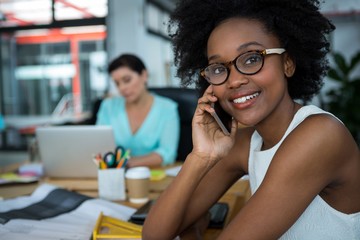 Female graphic designer smiling while phoning