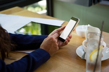 Woman using mobile phone in cafe