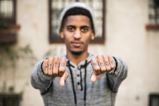 A closeup portrait of a young man shows off his tattoos in NYC