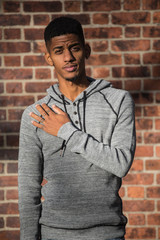 Obraz premium A young, hip, black man poses against a brick wall in NYC