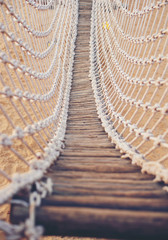 Young woman with backpack traveling over hanging bridge