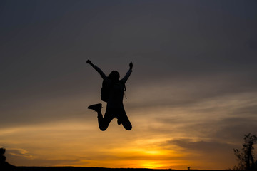 Fototapeta na wymiar Silhouette woman jumping at sunset