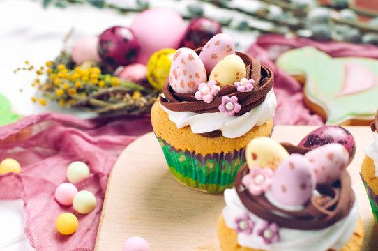 Easter cupcakes decorated with candy eggs in nest on Easter dinner table