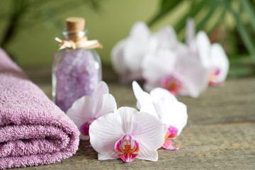 Spa still life with bath salt towel and orchids on wooden boards
