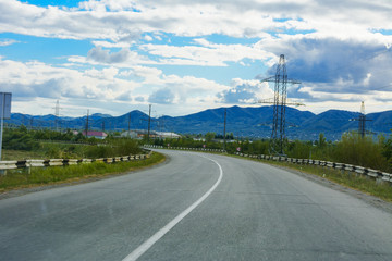 Fototapeta na wymiar Mountain road. The landscape of fields and mountains