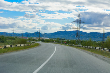 Fototapeta na wymiar Mountain road. The landscape of fields and mountains