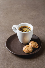 Italian homemade espresso coffee in a white mug. Dark background.