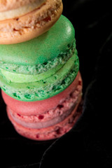 Macaroons on black velvet background. Isolated. French dessert.Close up