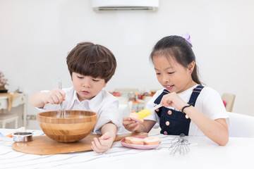 Obraz na płótnie Canvas Asian Chinese little brother and sister preparing to bake cookies