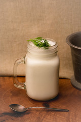 A glass of traditional Turkish cold drink ayran made of yoghurt on vintage background 